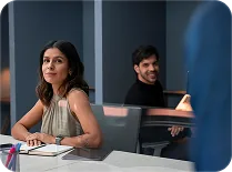Mujer y hombre conversando en una sala de reuniones de oficina
